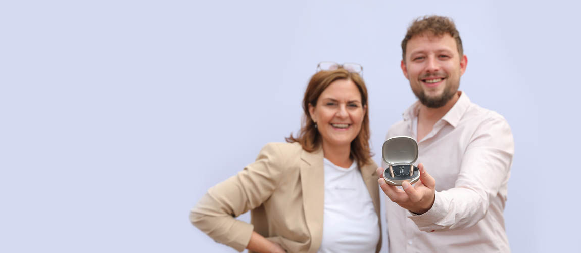 Carola Ise und Kilian Ise der ein Hörgerät in die Kamera hält